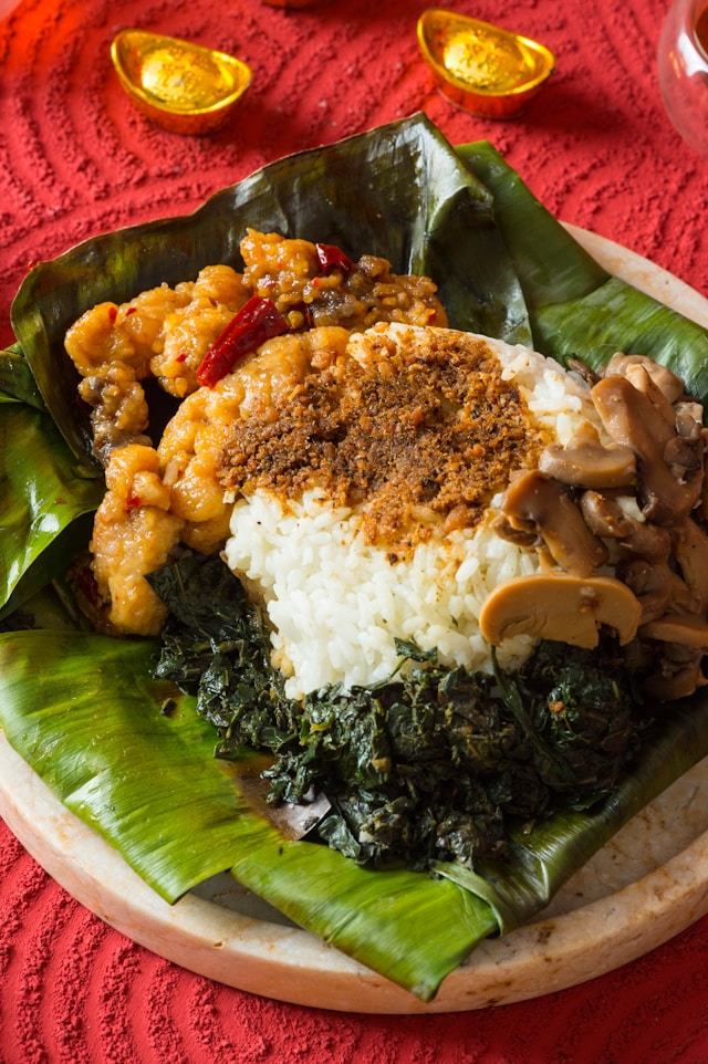 Nasi dengan lauk pauk di daun pisang